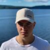 Beige keps med liten svart logga fram