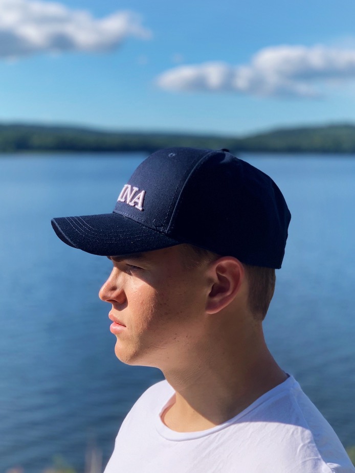 Marinblå keps med vit logga sida